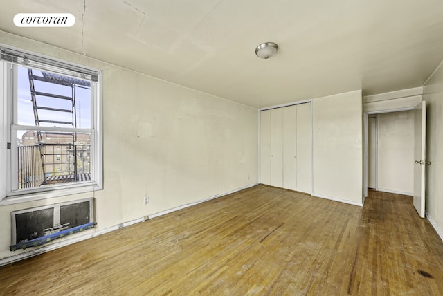 unfurnished bedroom featuring hardwood / wood-style floors, a closet, and visible vents