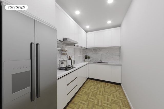 kitchen featuring light countertops, appliances with stainless steel finishes, a sink, and white cabinets