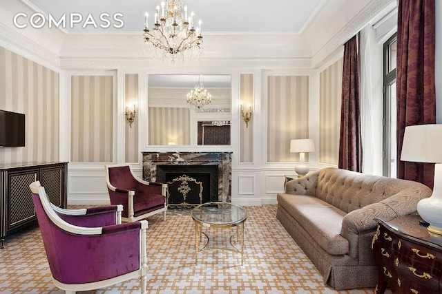 sitting room with an inviting chandelier, a high end fireplace, and ornamental molding