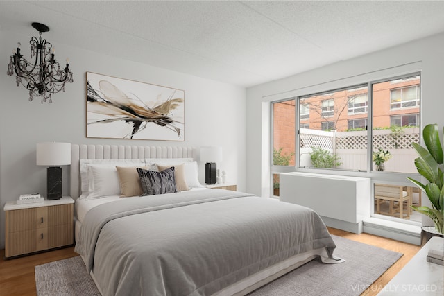 bedroom with wood-type flooring and a notable chandelier