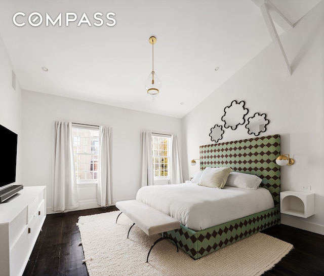 bedroom with baseboards, lofted ceiling, and dark wood-style floors