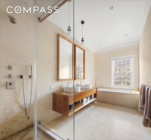 bathroom with tile patterned floors, a tile shower, and a sink