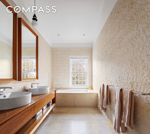 full bathroom with tile patterned flooring, plenty of natural light, and a sink