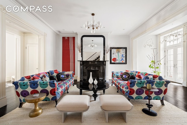 living area featuring french doors, wood finished floors, an inviting chandelier, and ornamental molding