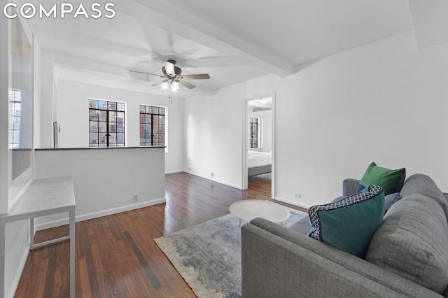 living room with ceiling fan, dark wood-type flooring, and beamed ceiling