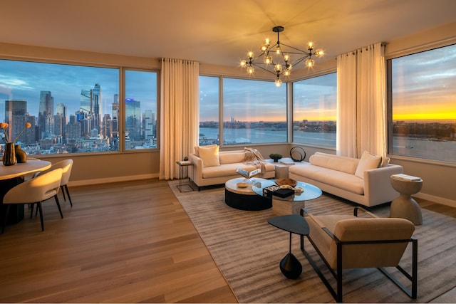 living area featuring baseboards, a chandelier, wood finished floors, and a view of skyline