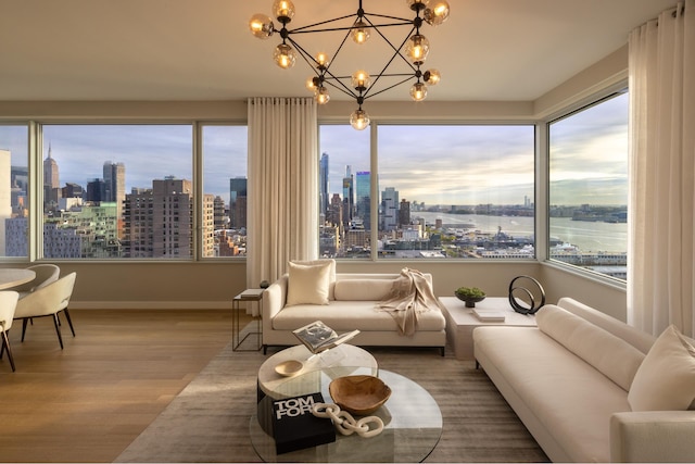 living area with a skyline view, wood finished floors, a chandelier, and baseboards