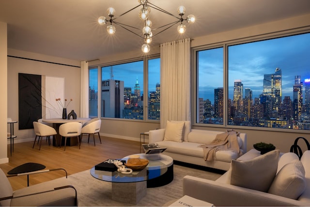 living area featuring wood finished floors, baseboards, a view of skyline, and a chandelier