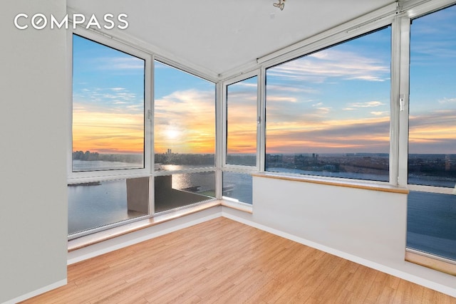 unfurnished sunroom featuring a water view