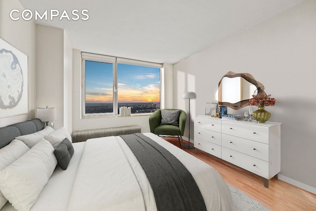 bedroom featuring light wood-style flooring and baseboards