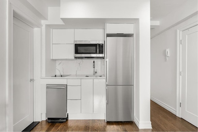 kitchen featuring white cabinetry, appliances with stainless steel finishes, tasteful backsplash, dark hardwood / wood-style flooring, and sink