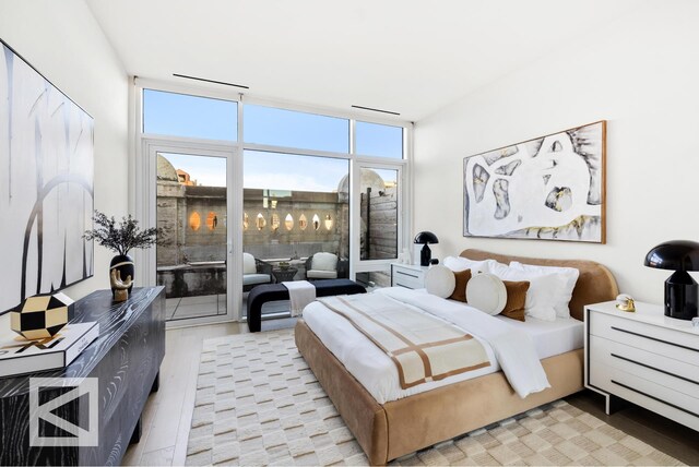 living room featuring a wall of windows and light hardwood / wood-style floors