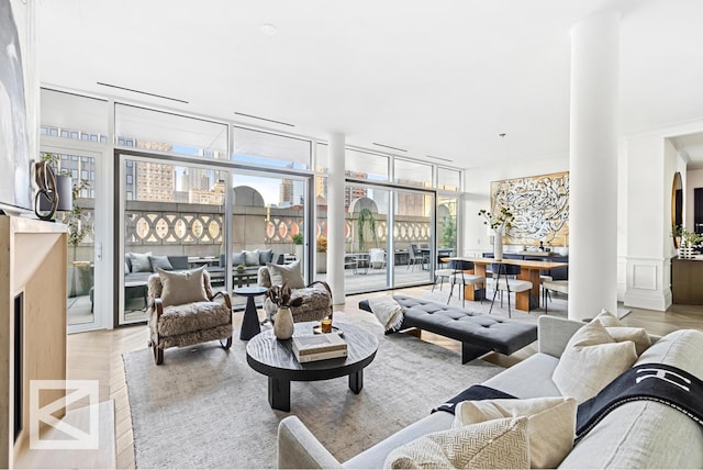 living room featuring a wall of windows, wood finished floors, and wainscoting