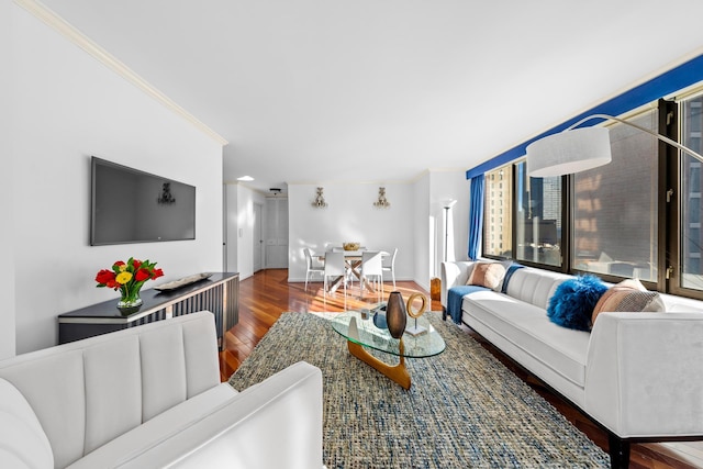 living area featuring baseboards, ornamental molding, and wood finished floors