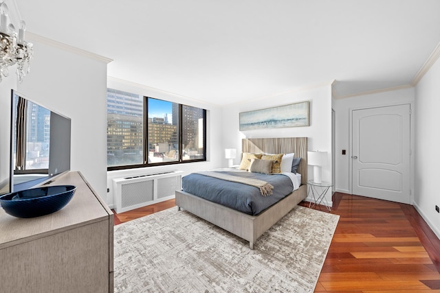 bedroom featuring radiator, baseboards, ornamental molding, and wood finished floors