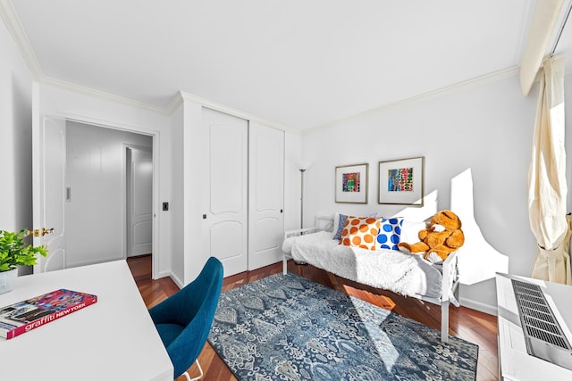 bedroom with a closet, wood finished floors, and crown molding