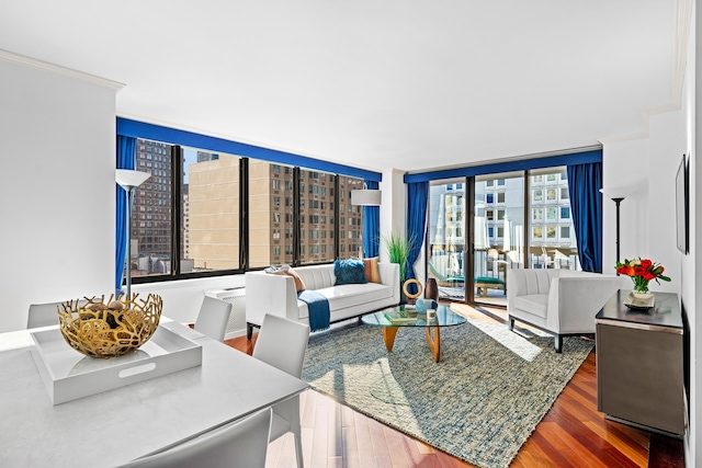 living room featuring expansive windows, ornamental molding, and wood finished floors