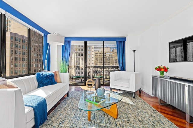 living room with expansive windows, ornamental molding, wood finished floors, and baseboards