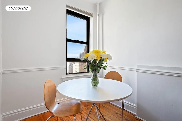 dining area with baseboards and wood finished floors
