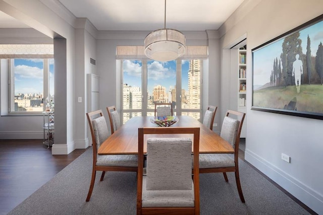 dining room with crown molding and dark wood-type flooring