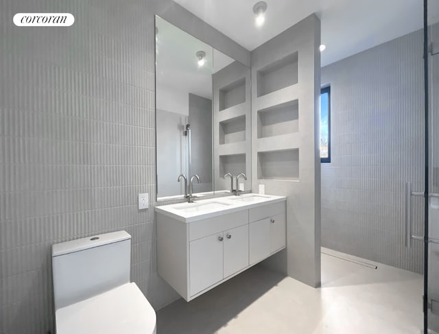 bathroom featuring a shower, tile walls, and vanity