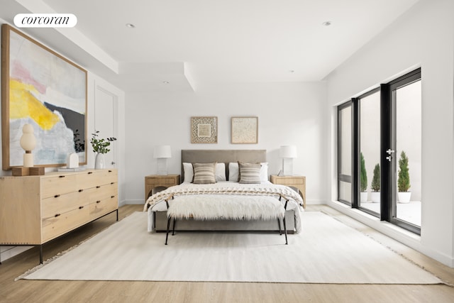 bedroom with baseboards, light wood-style floors, visible vents, and access to exterior