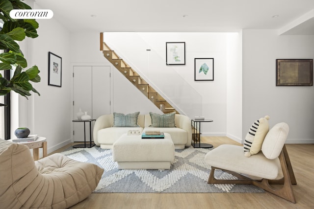 living room with stairs, wood finished floors, and baseboards