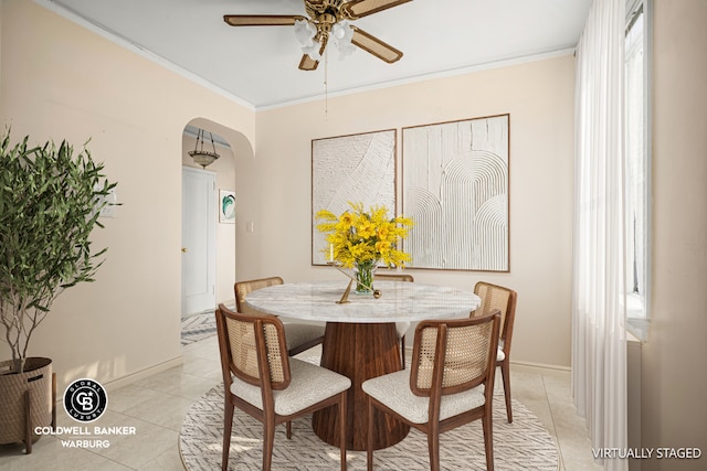 tiled dining space with ornamental molding and ceiling fan