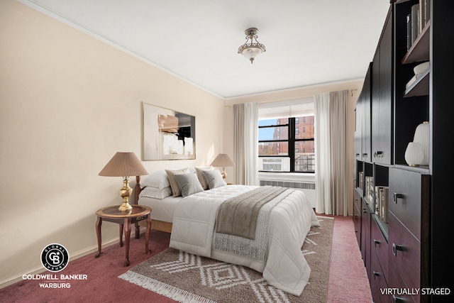 bedroom with crown molding and dark colored carpet