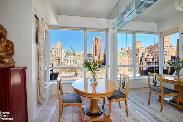 dining room featuring a view of city, baseboards, and light tile patterned flooring