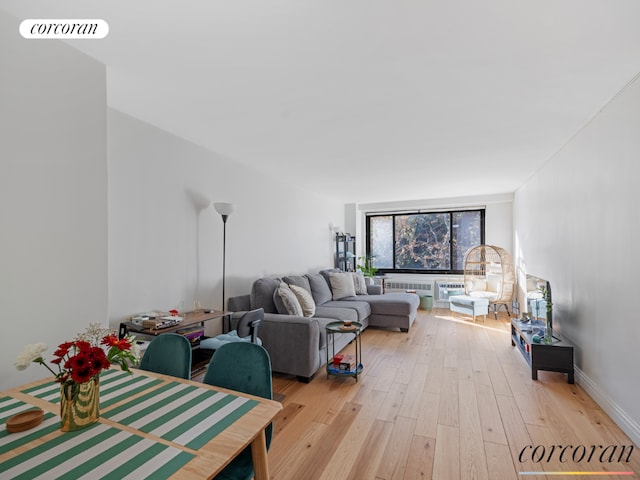 living room with light wood-style floors, baseboards, and visible vents