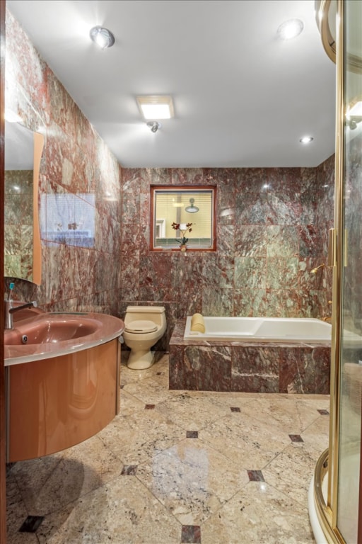 full bathroom featuring independent shower and bath, vanity, tile walls, and toilet