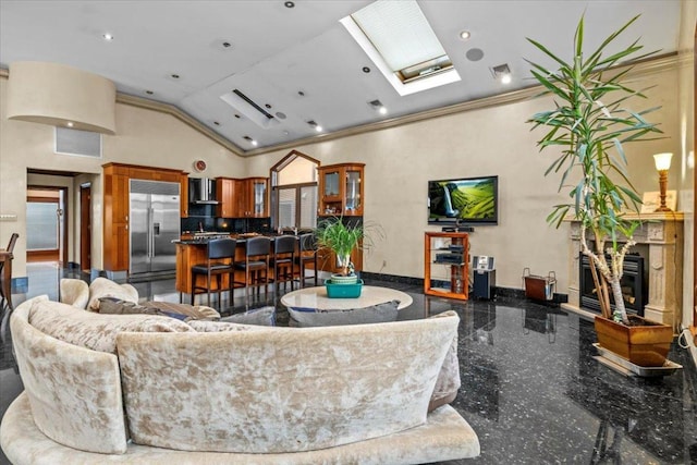 living room with high vaulted ceiling, a skylight, and ornamental molding