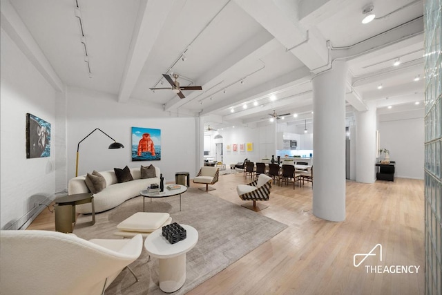 living room with ceiling fan, beamed ceiling, and light wood-type flooring