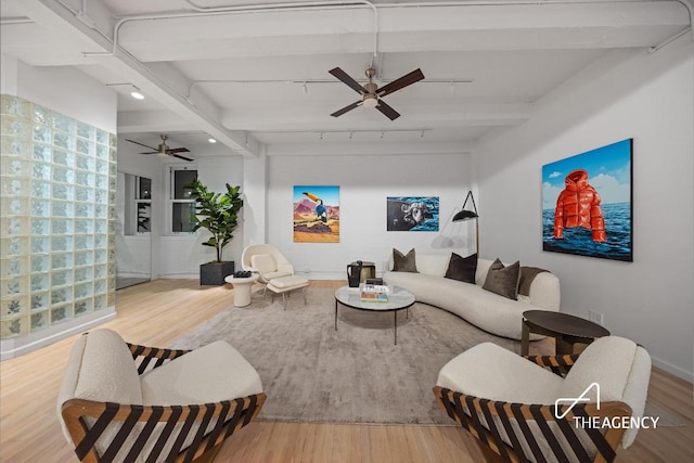 living room featuring hardwood / wood-style flooring, ceiling fan, rail lighting, and beamed ceiling