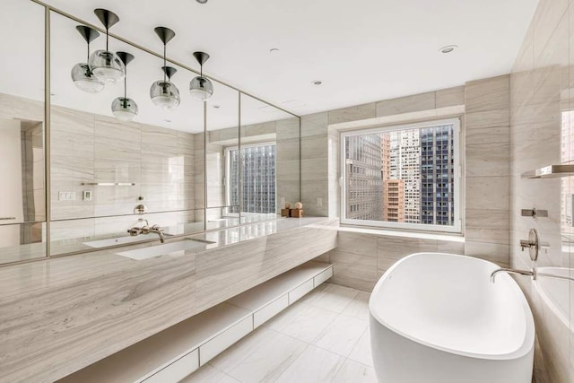 bathroom with a washtub, tile walls, and vanity