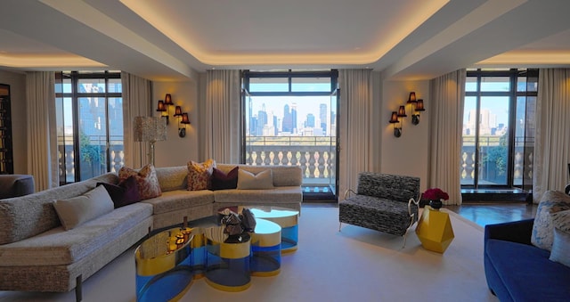 living room with a tray ceiling, floor to ceiling windows, and a wealth of natural light