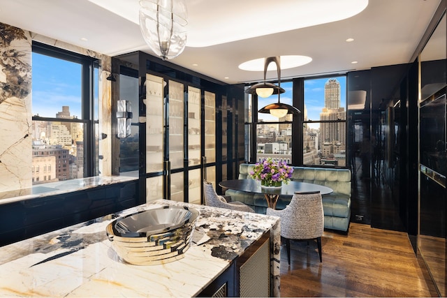 kitchen featuring a view of city, expansive windows, wood finished floors, and recessed lighting