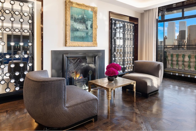 living area with a view of city and a lit fireplace