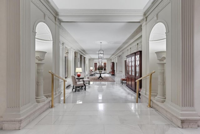 foyer with crown molding and a chandelier