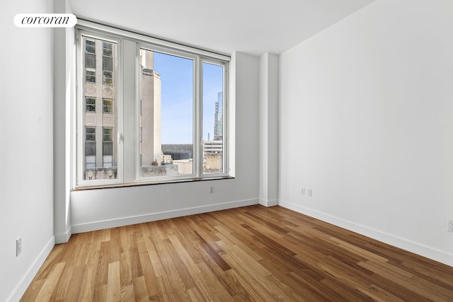 spare room with light wood-style floors and baseboards