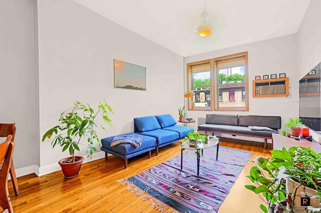 living room with a wall mounted AC and hardwood / wood-style flooring