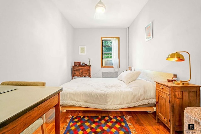 bedroom featuring cooling unit and wood finished floors