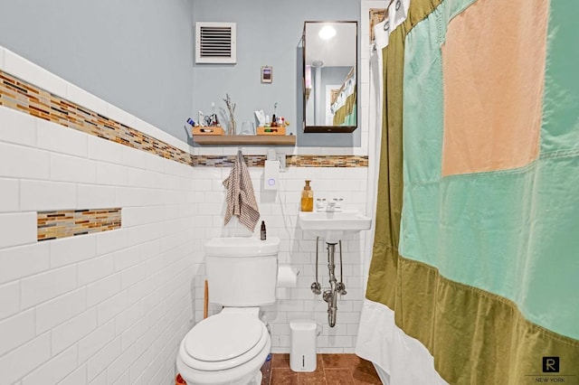 bathroom featuring visible vents, tile walls, toilet, and tile patterned floors