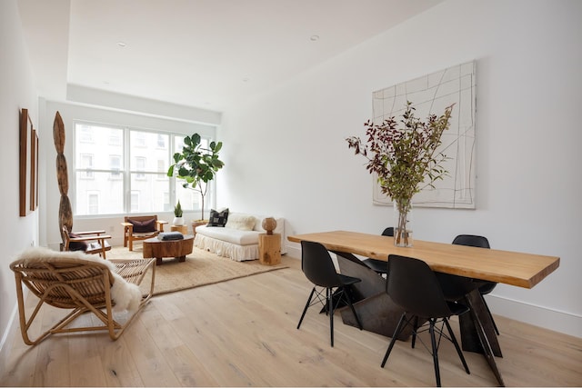 dining area with light wood-type flooring and baseboards
