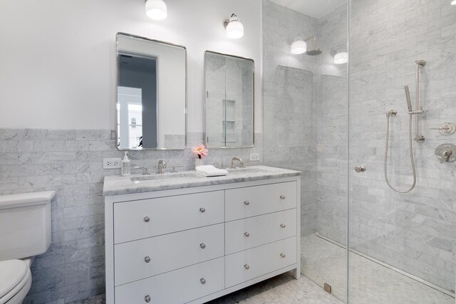 full bath with toilet, tile walls, walk in shower, double vanity, and wainscoting