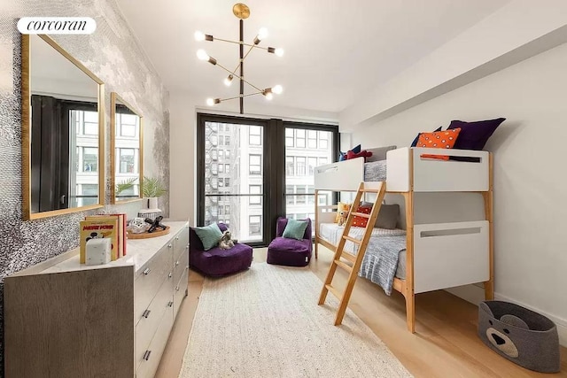 bedroom featuring an inviting chandelier and light wood-type flooring