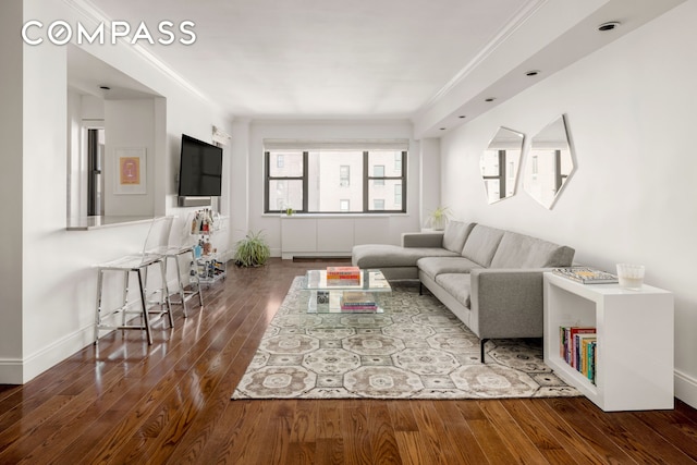 living area with a baseboard radiator, baseboards, hardwood / wood-style floors, and ornamental molding