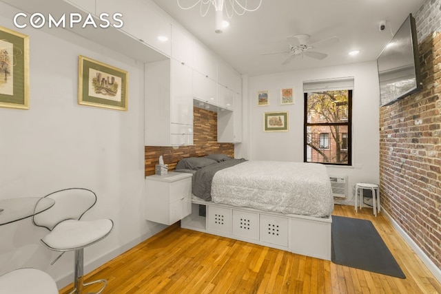 bedroom featuring light hardwood / wood-style floors and brick wall