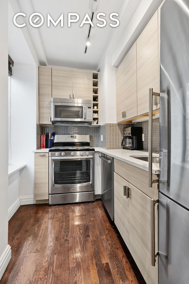 kitchen featuring modern cabinets, appliances with stainless steel finishes, light countertops, and decorative backsplash